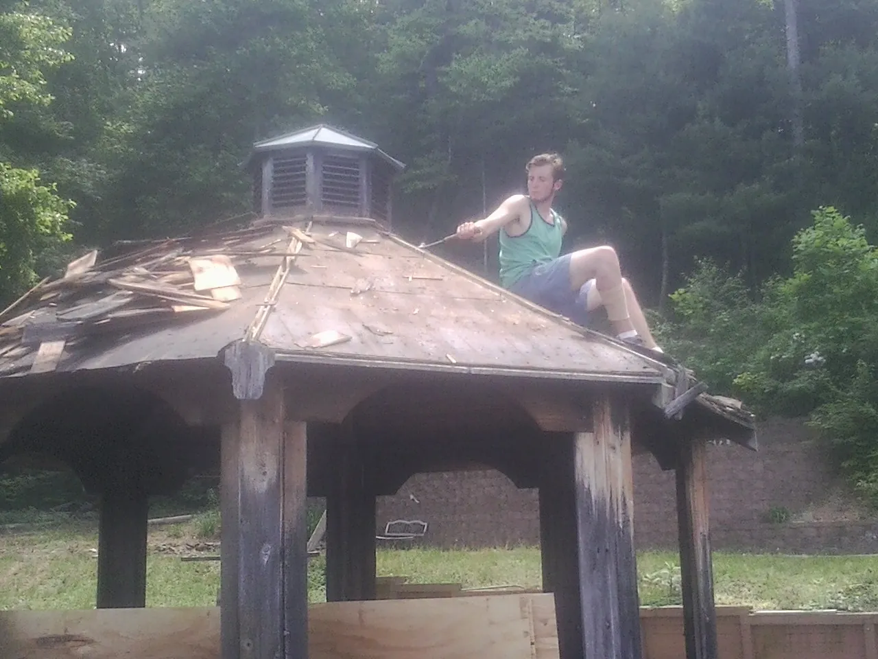 Tearing the old roof off a wooden gazebo before new shakes in Phil Campbell