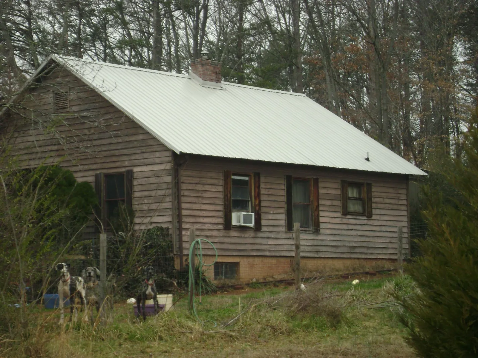 White metal roof on an old wood sided farmhouse, from a Metal Roof Installation job in Phil Campbell